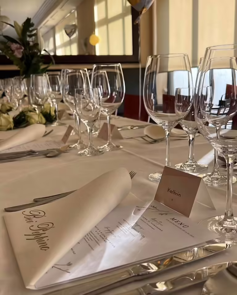 Festlich gedeckter Tisch bei Peppino Würzburg mit Wein- und Wassergläsern, Menü und Namenskärtchen für Feierlichkeiten